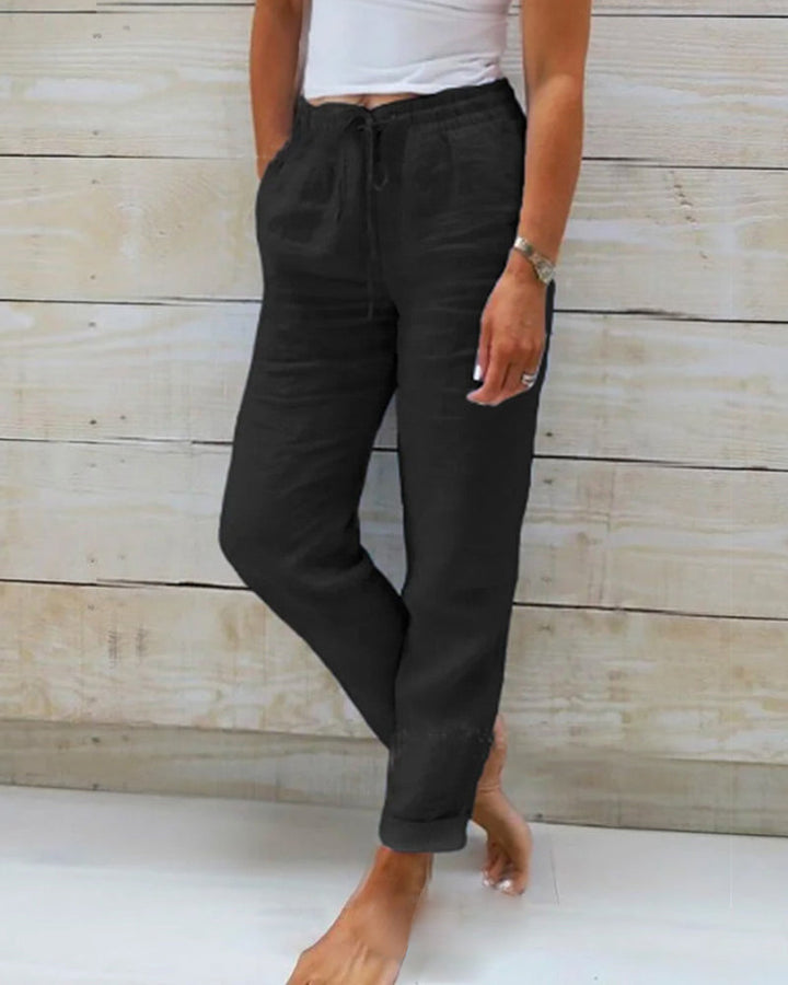 Black cotton trousers with drawstring waist and tapered leg cuffs