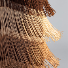 Brown fringe dress detail, tiered tassel strands along the hem and skirt