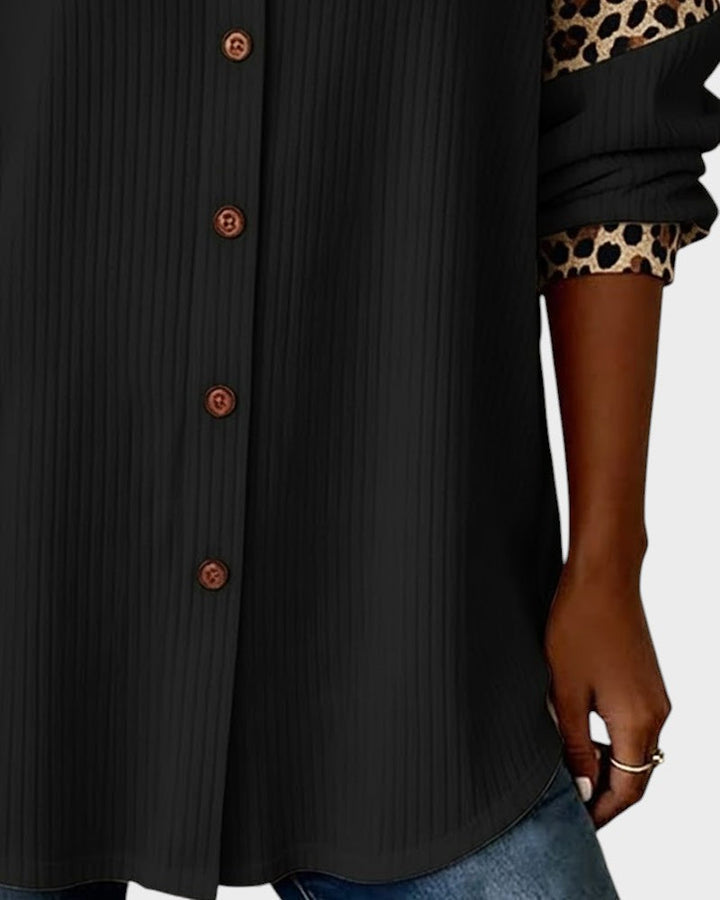 Black button-down shirt with textured fabric, brown buttons, and leopard cuff