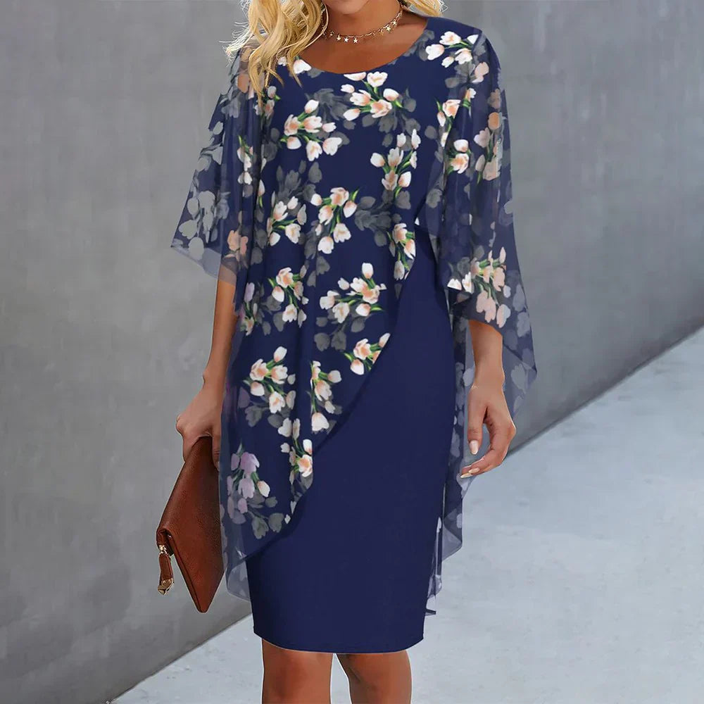 Floral cape dress featuring a navy sheath with sheer drape cape and allover flower print