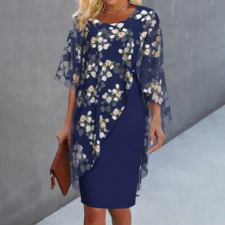 Floral cape dress featuring a navy sheath with sheer drape cape and allover flower print