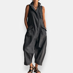 Black oversized sleeveless jumpsuit with open collar and chest patch pockets