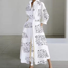 White shirt dress with black script print, long sleeves, collar, belted waist