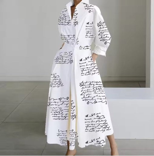 White shirt dress with black script print, long sleeves, collar, belted waist