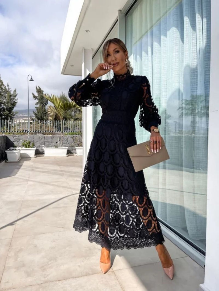 Black romantic lace dress with textured floral lace and long puff sleeves, midi hem.