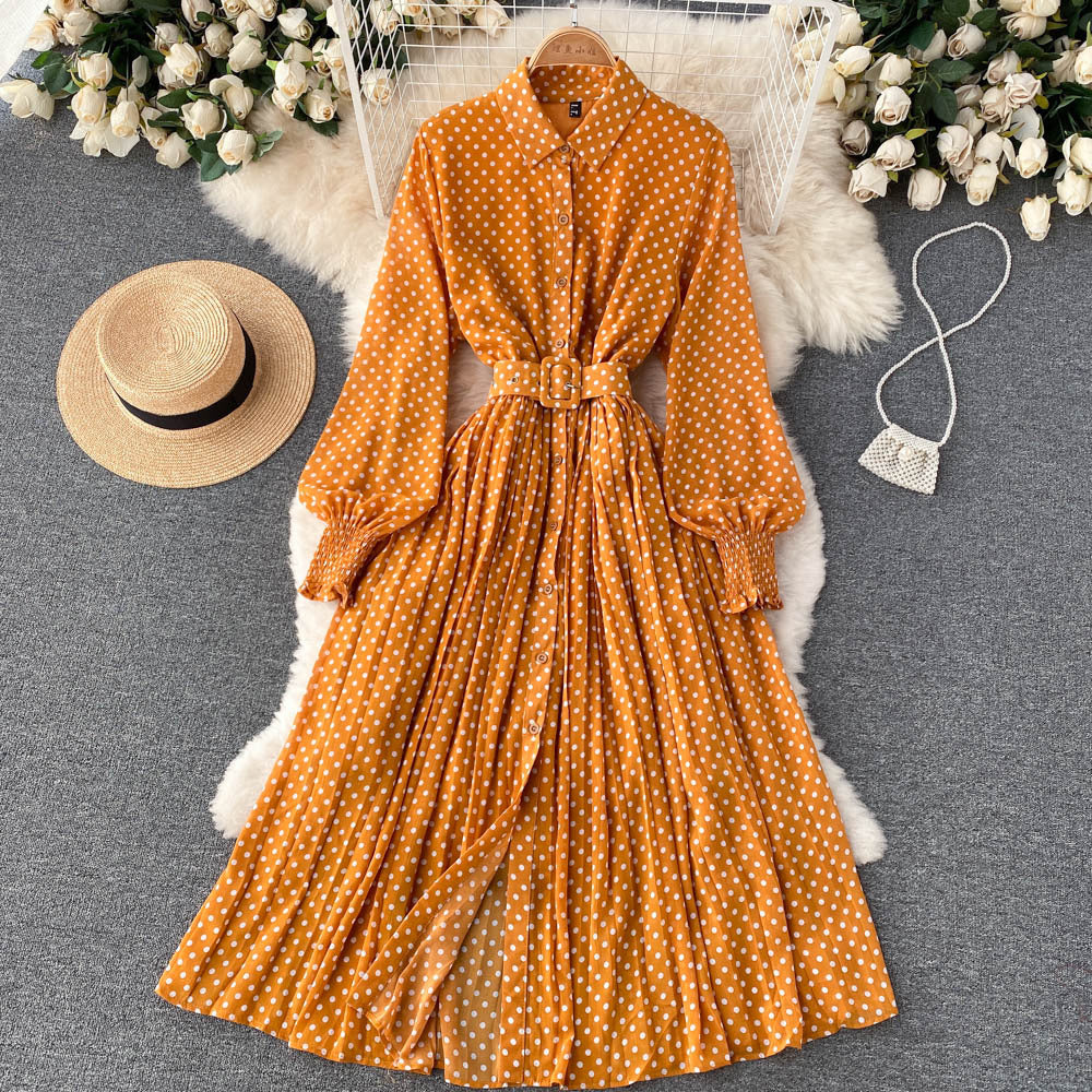 Orange polka dot chiffon pleated dress with button front, long sleeves, tied waist.