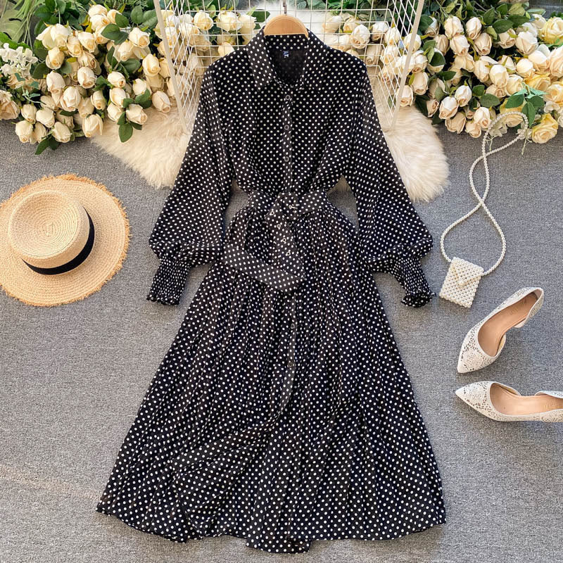 Black polka dot chiffon pleated dress with button front, long sleeves, tied waist.