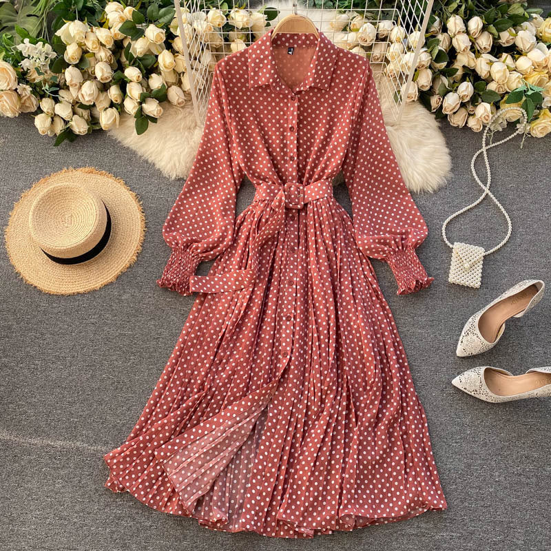 Red polka dot chiffon pleated dress with button front, long sleeves, tied waist.