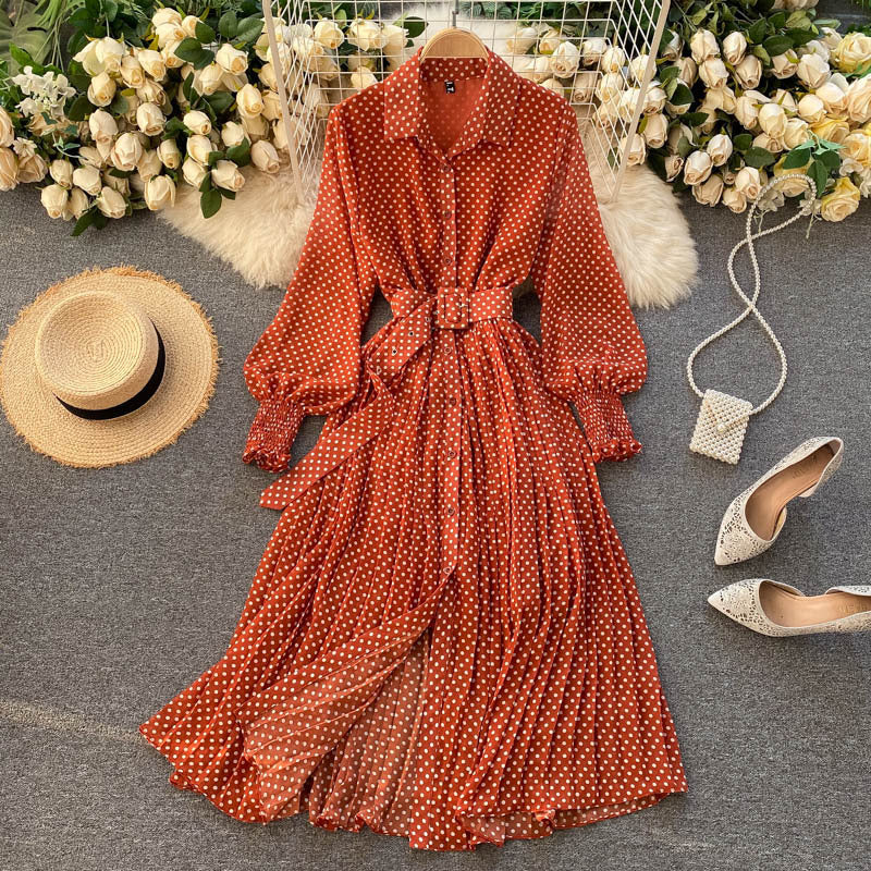 Burnt orange polka dot chiffon pleated dress with button front, long sleeves, tied waist.