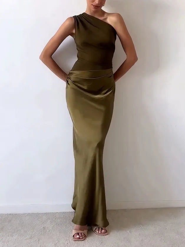 One-shoulder satin maxi dress in dark green with pleated waist and long fitted skirt.