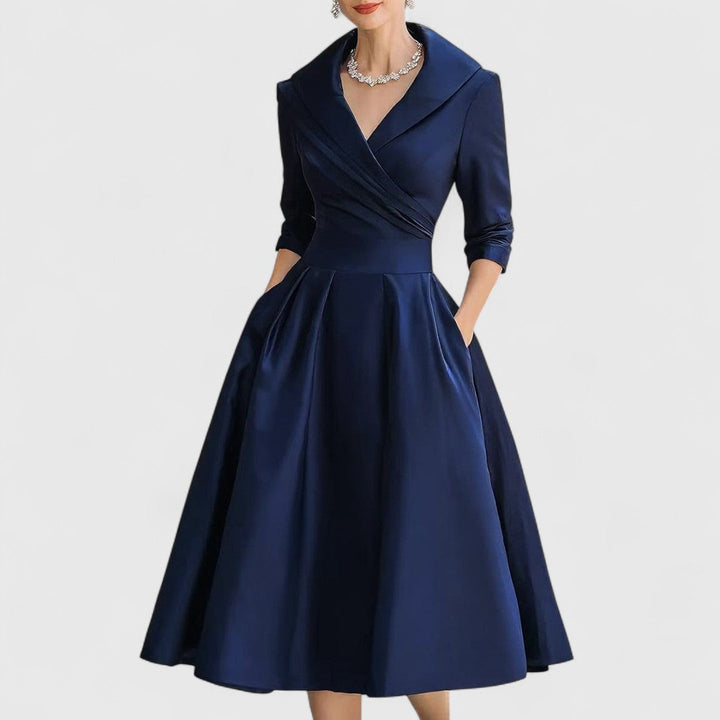 Navy blue midi wrap dress with V-neck, 3/4 sleeves, pleated full skirt.