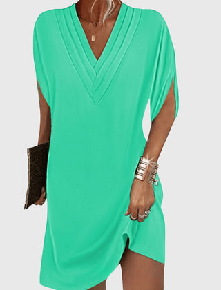 Bright green draped V-neck dress with short sleeves and wrap-like crossover front
