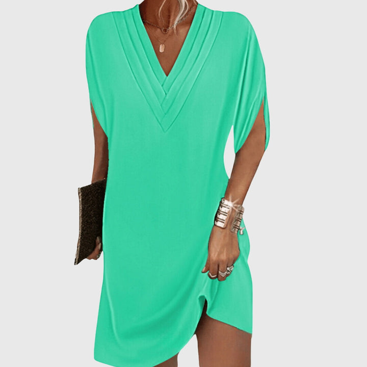 Bright green draped V-neck dress with short sleeves and wrap-like crossover front