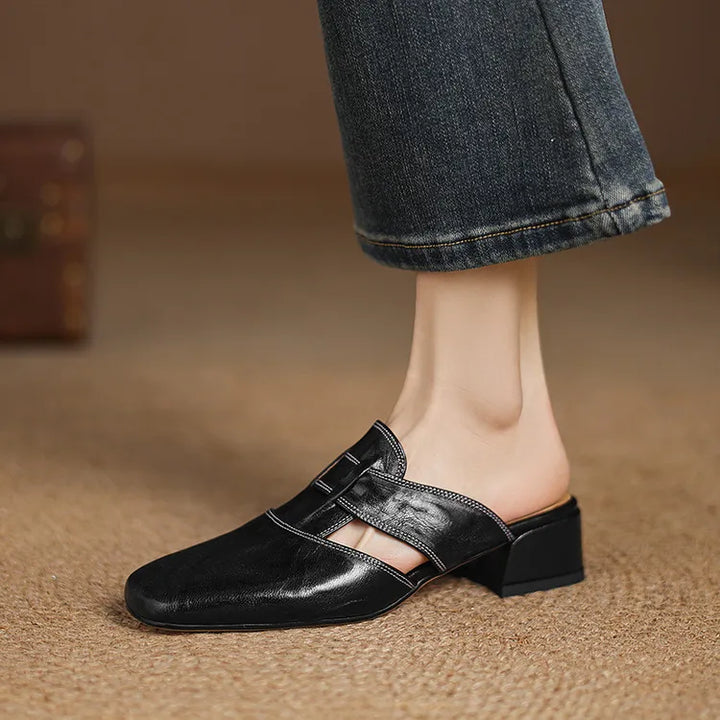 Black genuine leather mule with square toe and side strap detail, block heel.