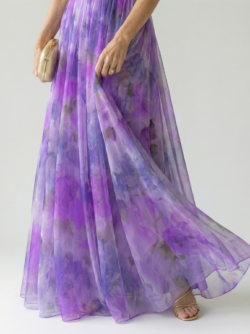 Close-up of purple pleated maxi skirt with airy tulle overlay and wrap waist detail, side view.