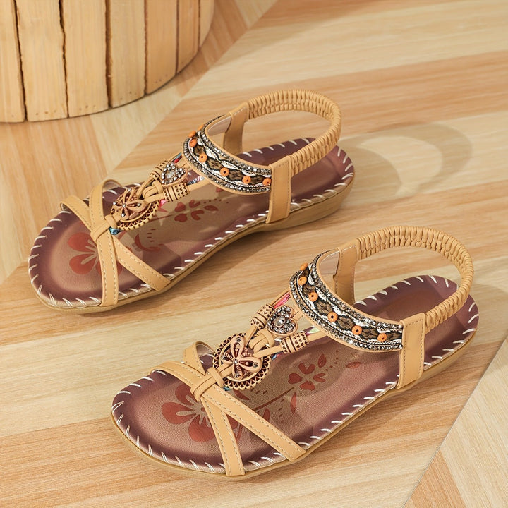 Light tan boho flat sandals with open toe, beaded trim, decorative charm accents