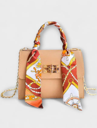 Beige handbag with gold clasp, chain strap, and red patterned scarf handle