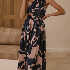 Navy sleeveless maxi dress with pink abstract floral print and tie waist belt, standing