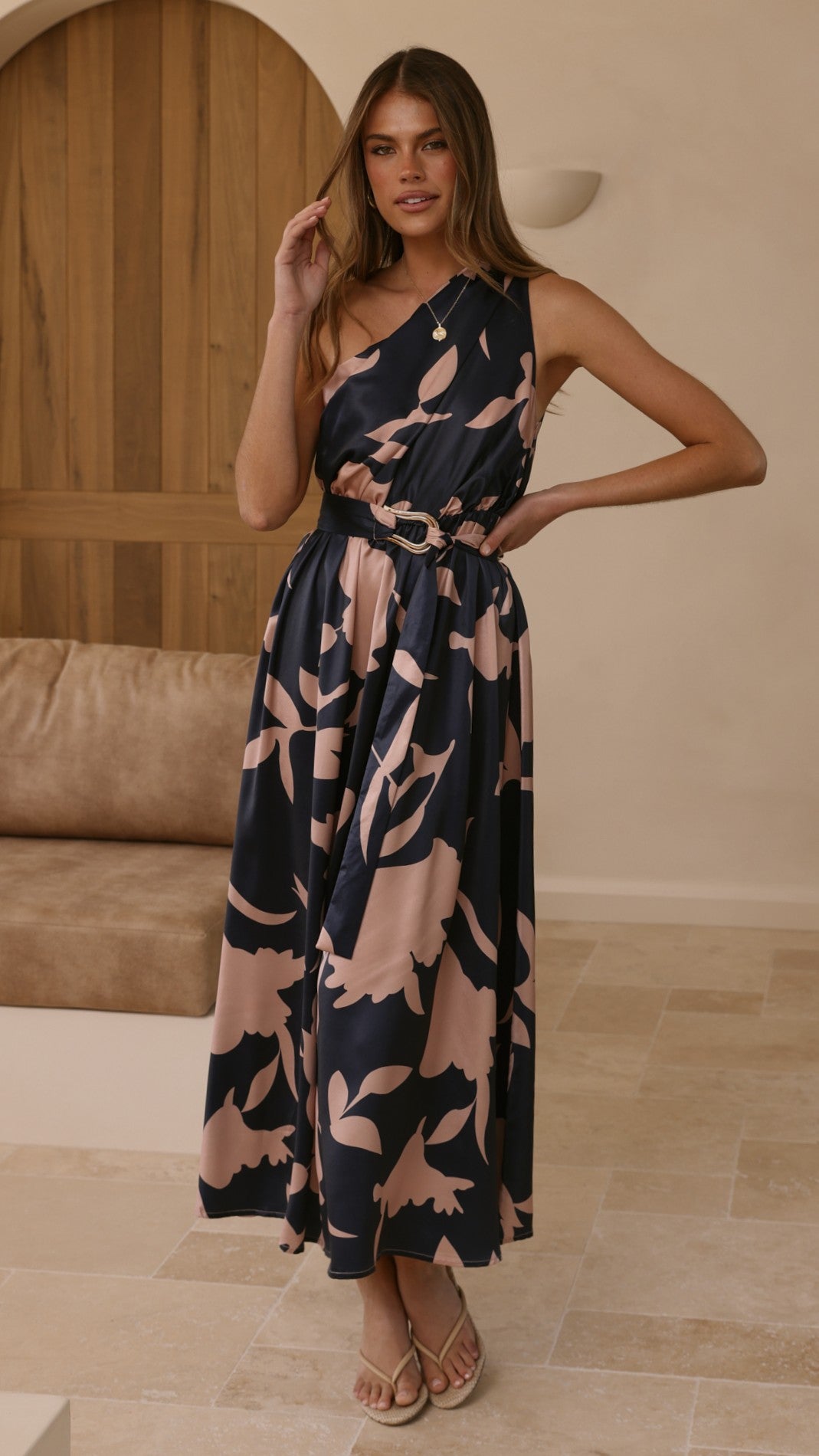 Navy sleeveless maxi dress with pink abstract floral print and tie waist belt, standing