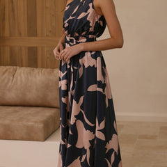 Navy maxi dress with pink floral print, sleeveless V-neck, belted waist, standing view.
