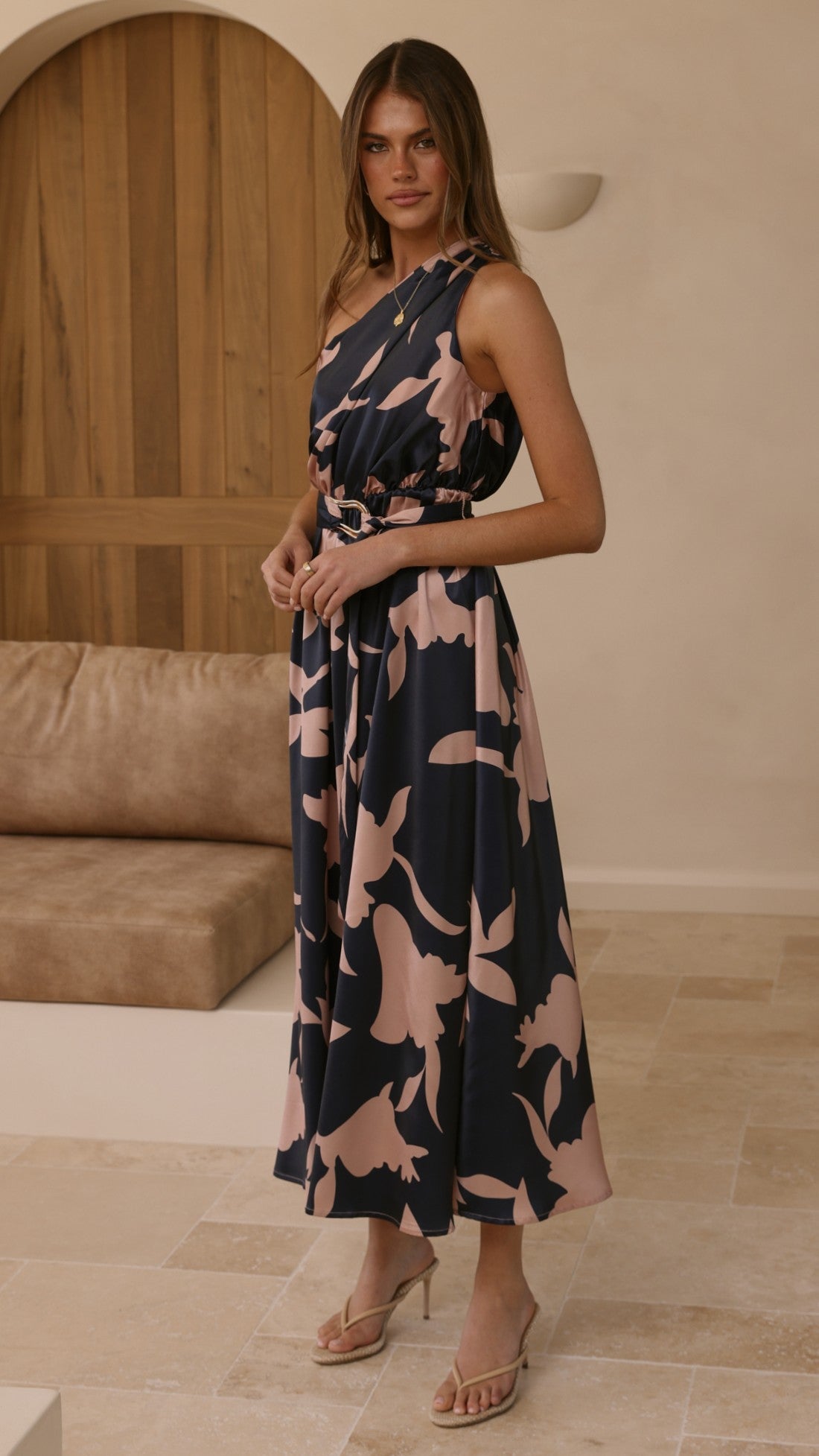 Navy maxi dress with pink floral print, sleeveless V-neck, belted waist, standing view.