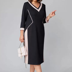 Black V-neck dress with contrast white trim, 3/4 sleeves, knee-length shift silhouette