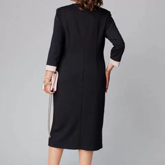 Black V-neck dress back view with white contrast trim along seams, 3/4 sleeves