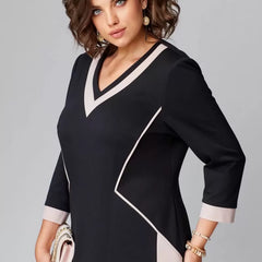 Black V-neck dress with white neckline trim and angled contrast seam detail