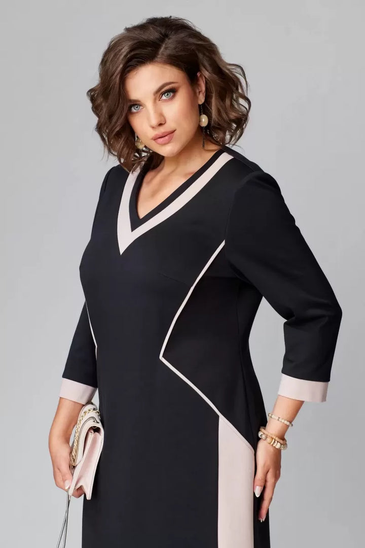Black V-neck dress with white neckline trim and angled contrast seam detail