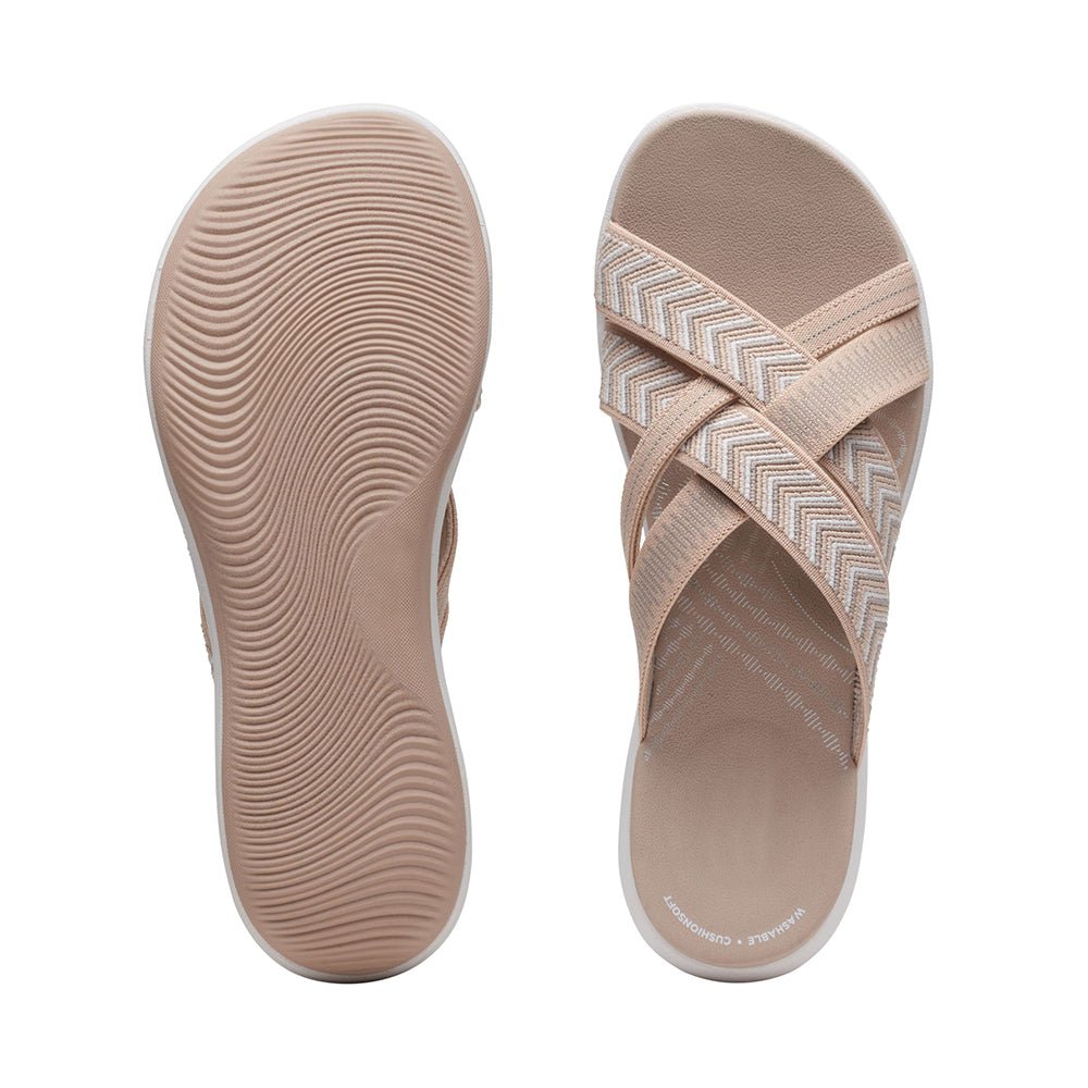 Beige sandals showing textured footbed and chevron strap upper.