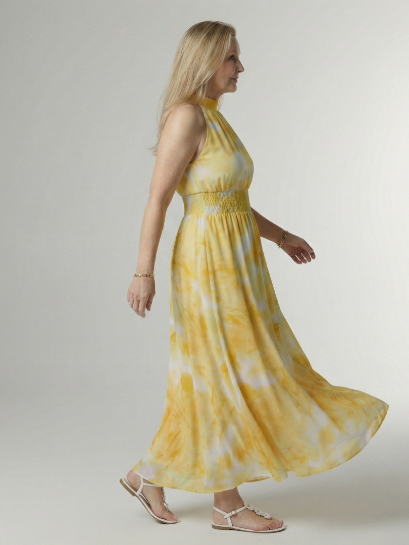 Yellow tie-dye halter midi dress with smocked waist and flowing gathered skirt