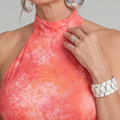 Orange halter neck maxi dress with pink abstract print, sleeveless neckline close-up