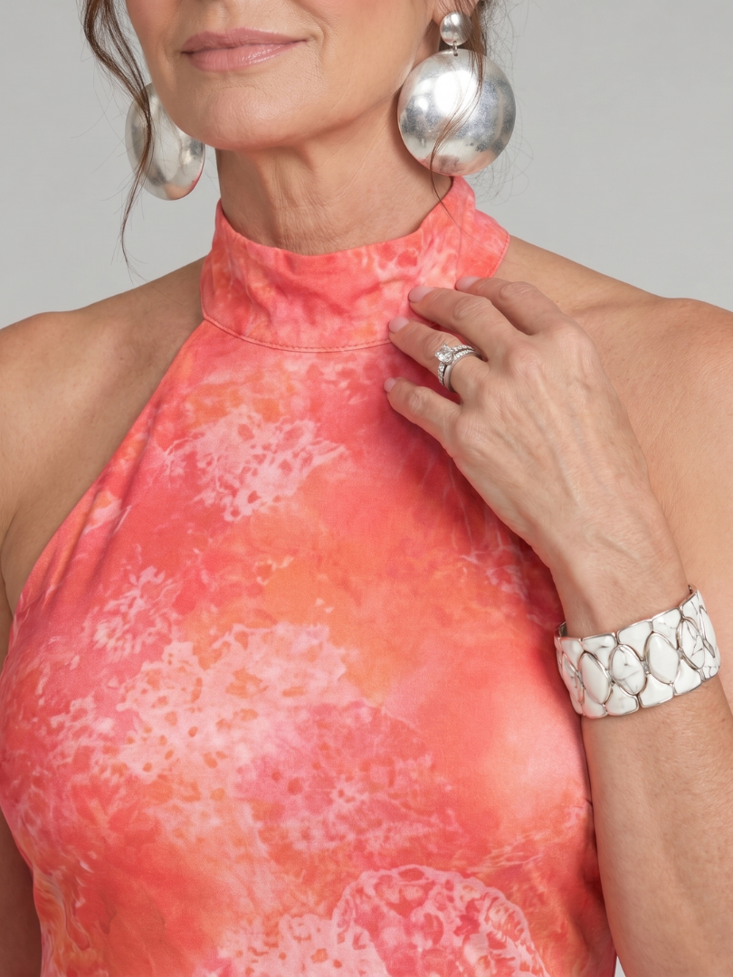 Orange halter neck maxi dress with pink abstract print, sleeveless neckline close-up