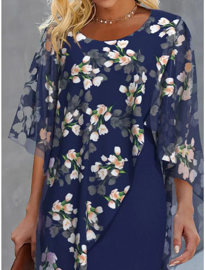Floral cape dress with navy blue sheath and sheer overlay sleeves, scattered bouquet print