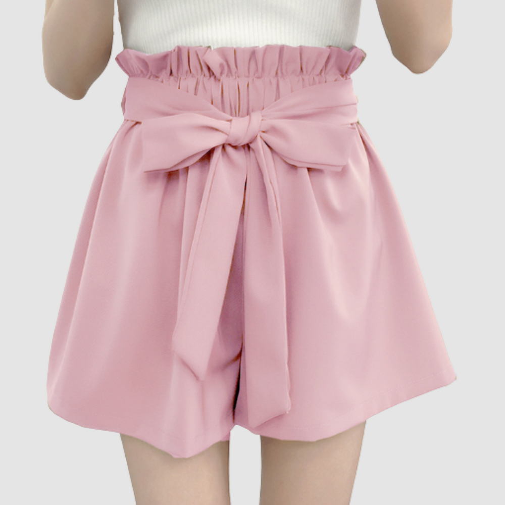 Pink paperbag waist shorts with large tied bow, pleated elastic waist front.