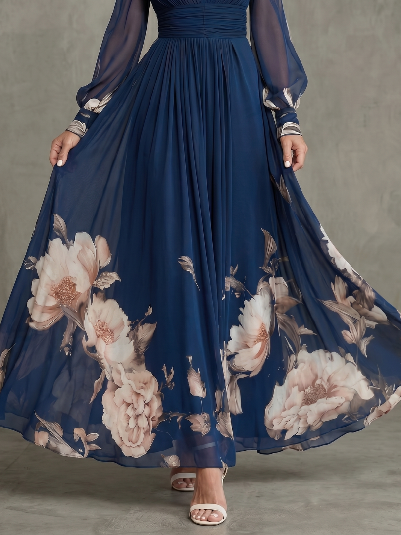 Navy pleated maxi skirt with large blush floral print and sheer long sleeves