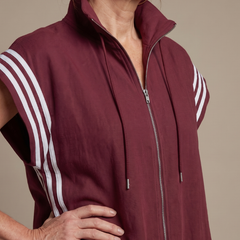 Burgundy sleeveless zip jumpsuit with white striped sleeve panels and drawstring hood