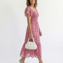 Pink floral off-shoulder smocked midi dress with short puff sleeves, white handbag
