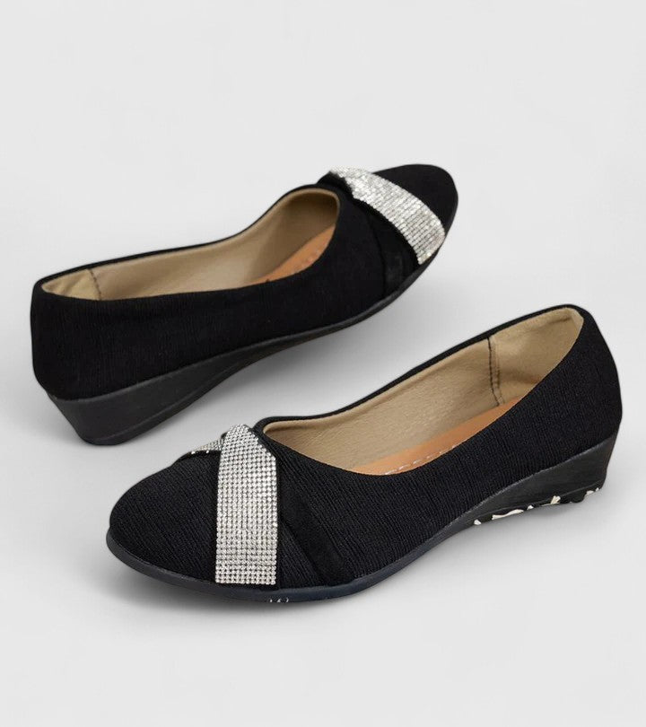 Pair of black orthopedic slip-on flats with silver glitter strap detail