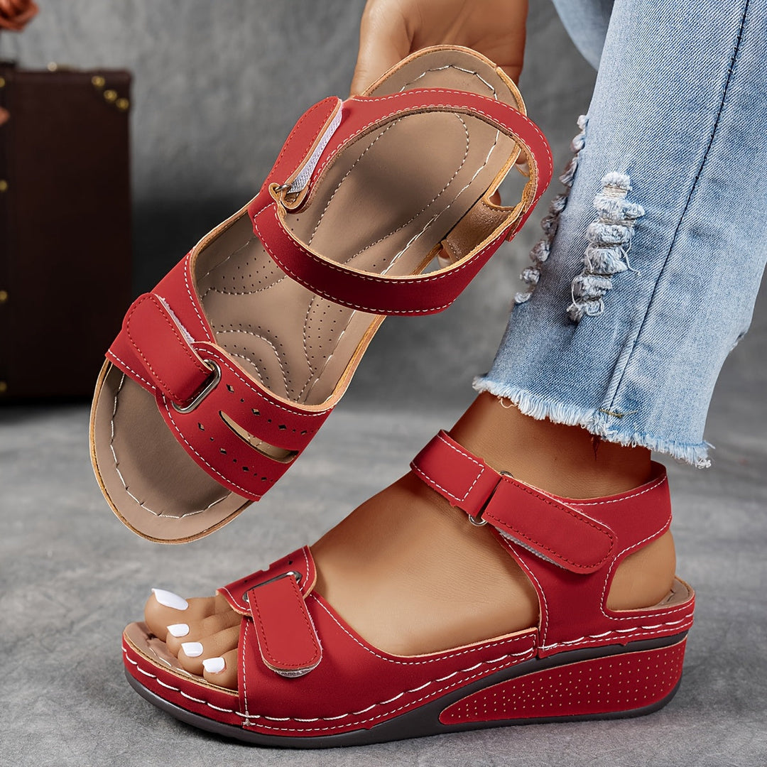 Red orthopedic sandal with adjustable Velcro straps, open-toe, cushioned footbed.