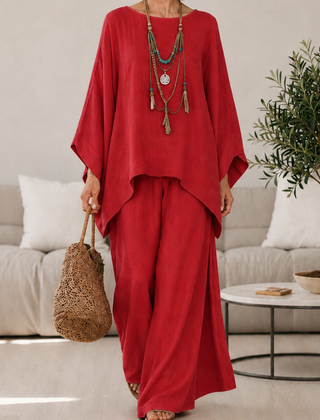 Red two-piece set with draped tunic top and wide-leg pants, long sleeves.