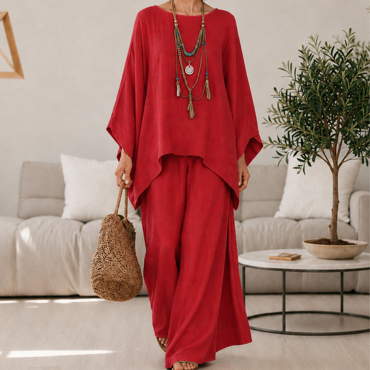 Red two-piece set with draped tunic top and wide-leg pants, long sleeves.