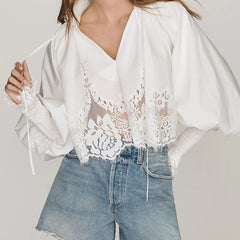 White V-neck lace blouse with puff sleeves and scalloped lace detailing over the front