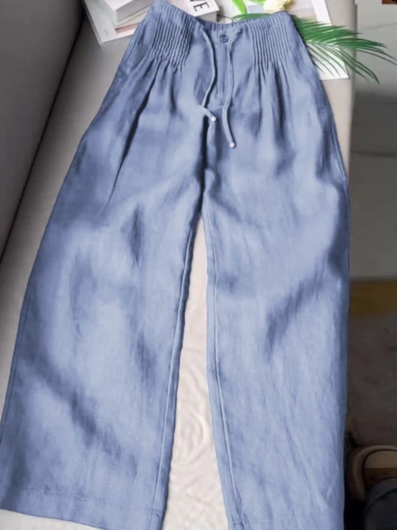 Blue wide-leg trousers with elastic waistband, drawstring, and front button