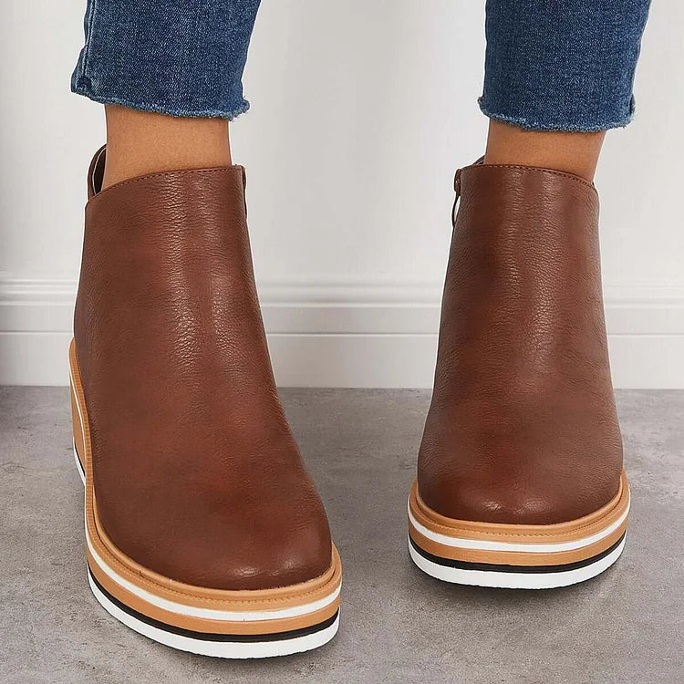 Brown ankle boots with side zippers and tan-striped platform soles