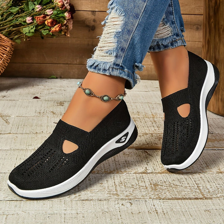 Black knit orthopedic slip-on shoes with oval cutouts and white sole