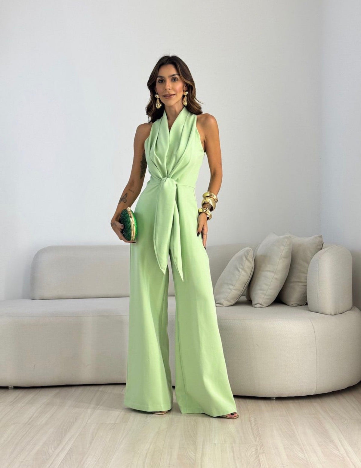 Light green sleeveless jumpsuit with wrap V-neck and tied waist, wide-leg