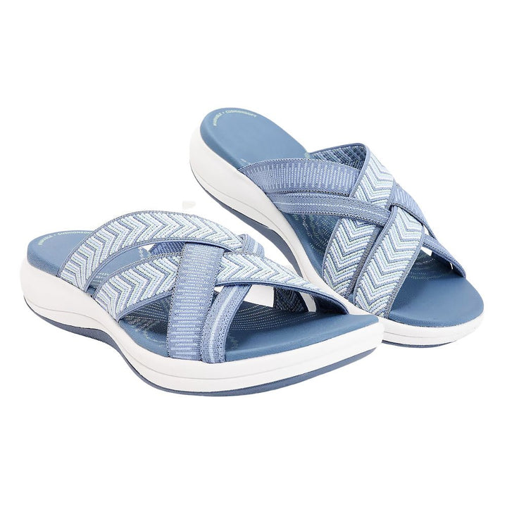 Light blue orthopedic comfort sandals with chevron strap and open-toe design.