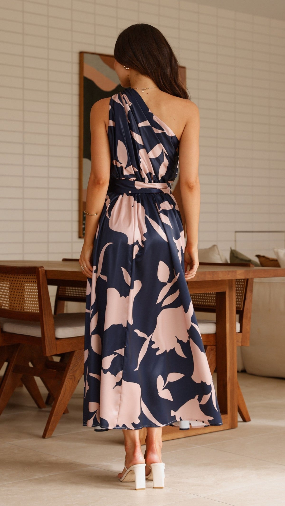 Navy maxi dress with pink floral print, open back, belted waist, back view.