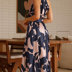 Navy sleeveless maxi dress with pink abstract floral print and tie waist belt, side view